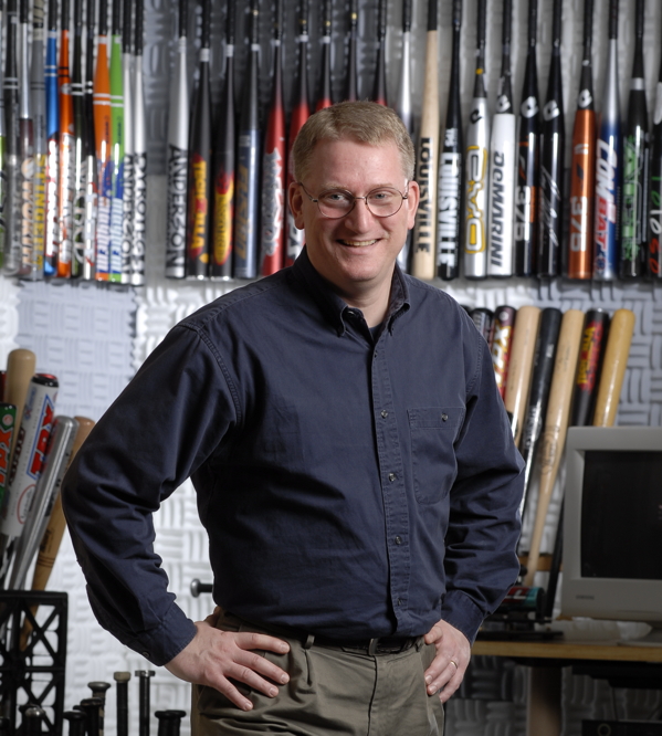 photograph of Dr. Russell in front of his baseball bat collection. Photo taken in 2009.